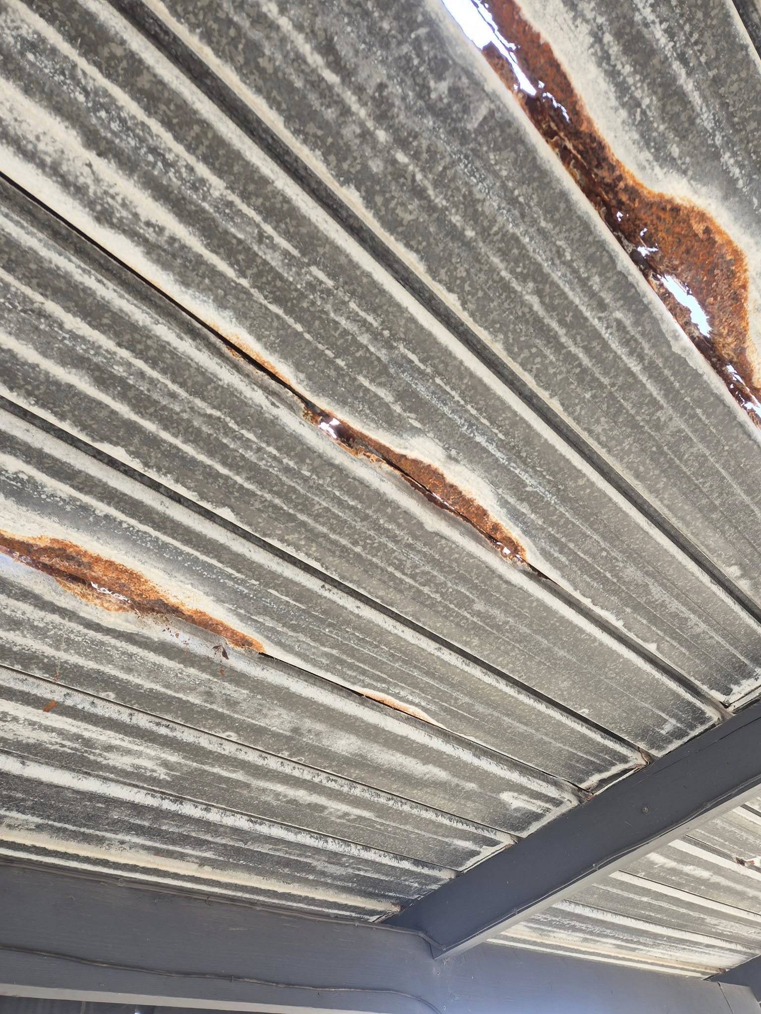Old carport roof sheeting rusted through in several places