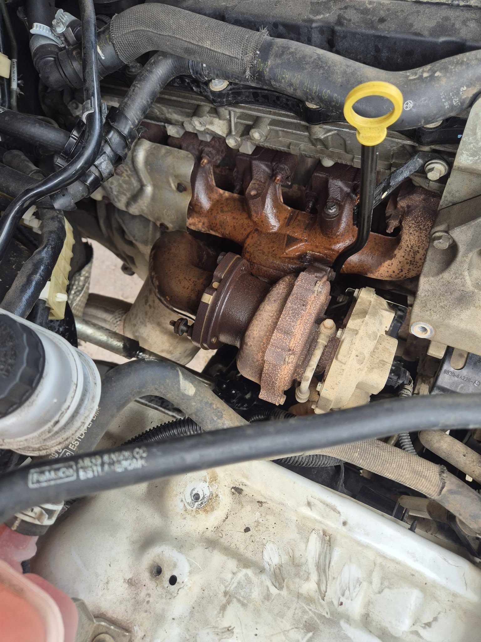 Original turbocharger and manifold in place, heavily rusted