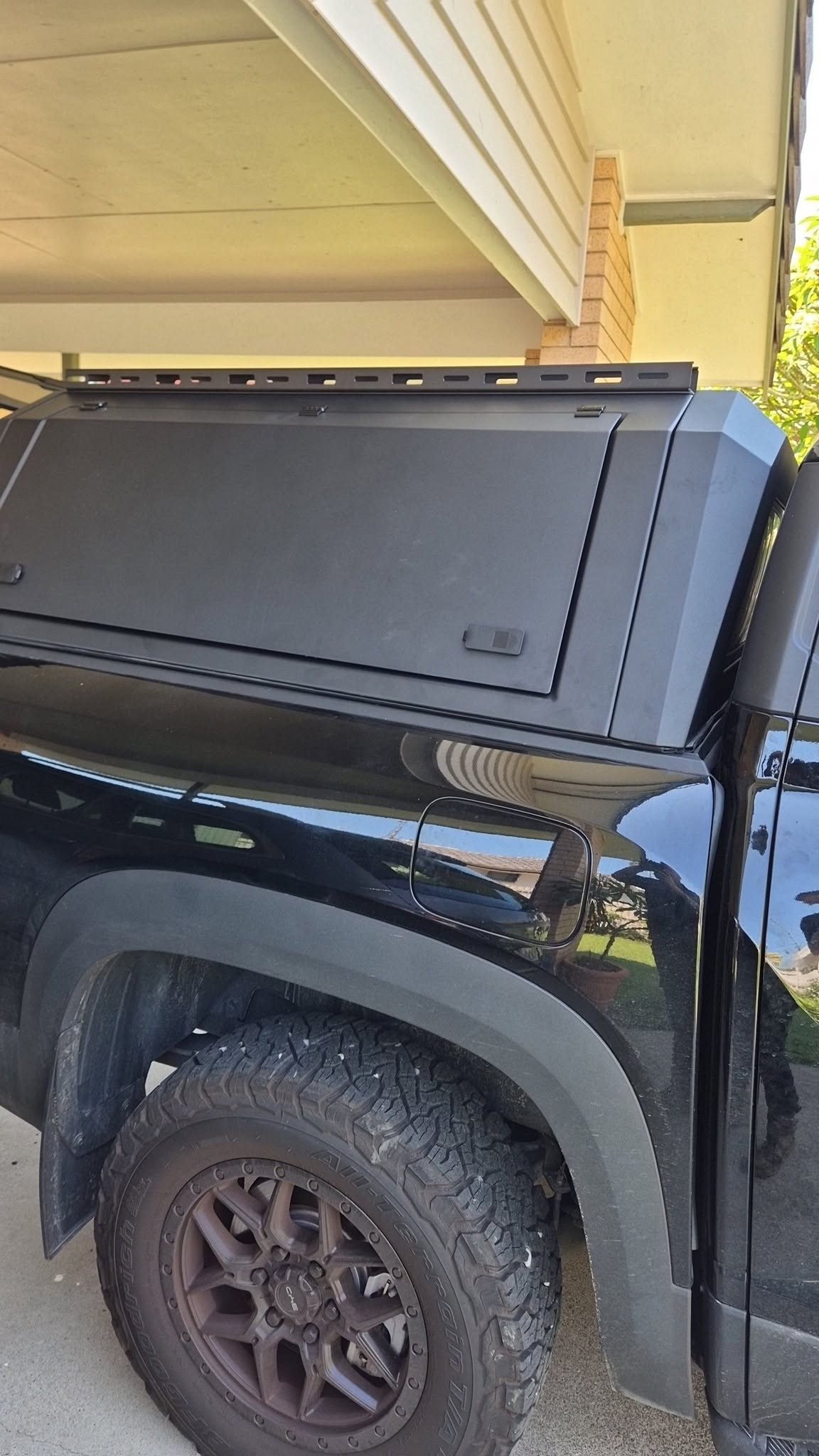 Steel canopy fitted to the tray of a black ute